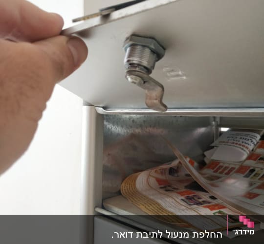 יד פותחת מנעול תיבת דואר עם מפתח